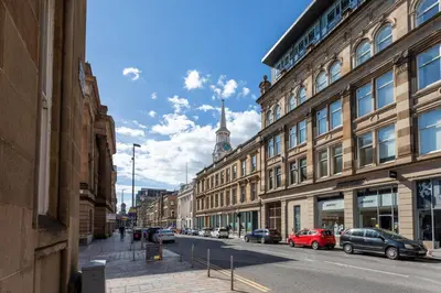 a city street with buildings and cars parked on the street at Merchant City Apartment in Glasgow