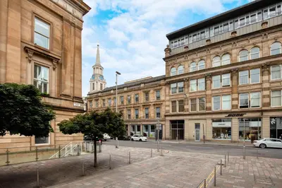 a large building with a steeple in the background at Merchant City Apartment in Glasgow