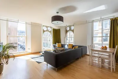 a living room with a couch and a table at Merchant City Apartment in Glasgow
