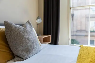 a bedroom with a bed with a pillow and a window at Merchant City Apartment in Glasgow