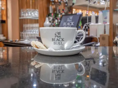 a coffee cup and a plate on a counter at Blackbull hotel in Tarbolton