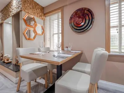 a dining room with a wooden table and white chairs at Blackbull hotel in Tarbolton