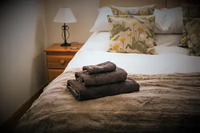 two towels sitting on the end of a bed at Auchnabreac Cottage in Carradale