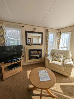 a living room with a tv and a couch and a table at The Ashcroft Sea View 6 in Dunoon
