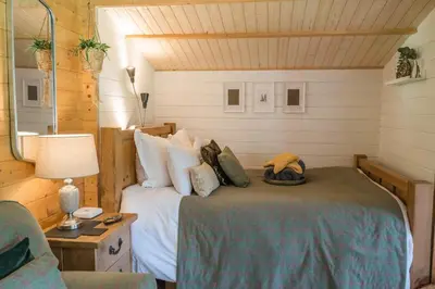 a bedroom with a bed in a room at 1-Bed Cabin 2 adults Wood Burning Hot Tub & Fire in Carluke