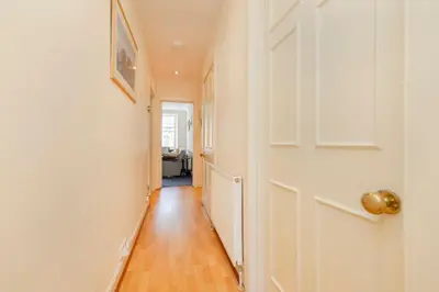 a hallway with a white door and a wooden floor at JOIVY Gorgeous 2-bed flat near Edinburgh Castle in Edinburgh