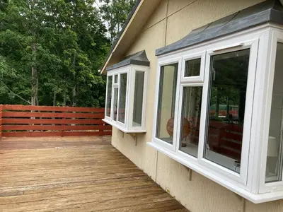 a porch with white windows on the side of a house at Lochay Lodges in Killin