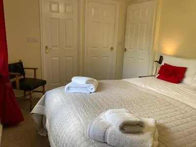 a bedroom with a white bed with towels on it at Lochay Lodges in Killin