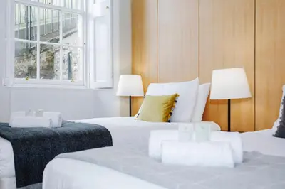 a bedroom with two beds and two lamps and a window at JOIVY Lovely Flat in the Heart of Edinburgh in Edinburgh
