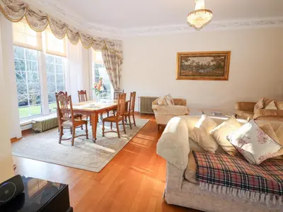 a living room with a couch and a table at Auchentroig House in Stirling