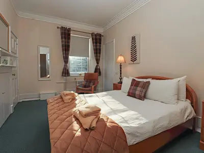 a bedroom with a bed with a dog laying on it at Auchentroig House in Stirling