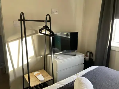 a bedroom with a bed and a television on a dresser at Peacock Guest House in Largs