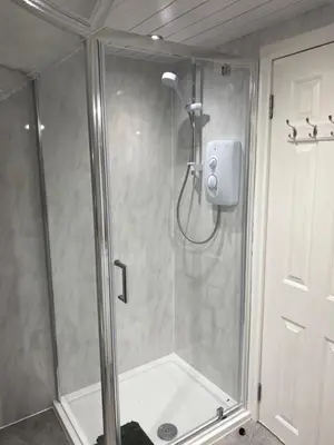 a shower with a glass door in a bathroom at Peacock Guest House in Largs