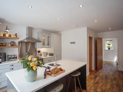 a kitchen with a counter with a vase of flowers on it at Squirrel Cottage in Stranraer