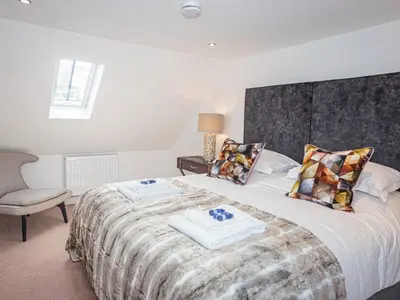 a bedroom with a bed with two towels on it at Squirrel Cottage in Stranraer