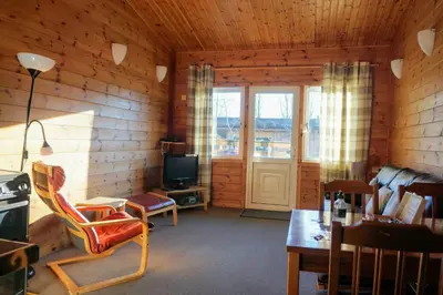 a living room with a couch and a tv and a table at Woodland Hazel Lodge in Killin