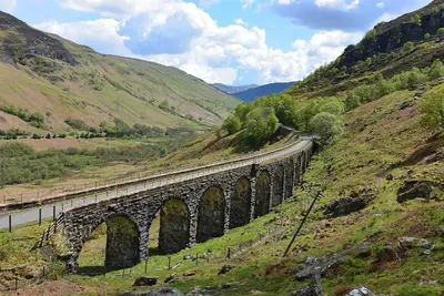 a bridge on a hill with a train on it at Woodland Spruce Lodge in Killin