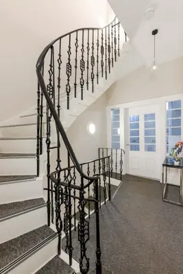 a spiral staircase in a home with white walls at Dragon Suites - Edinburgh City Centre 2 Bed Apartment in Edinburgh