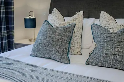 a bed with four pillows at Dragon Suites - Edinburgh City Centre 2 Bed Apartment in Edinburgh