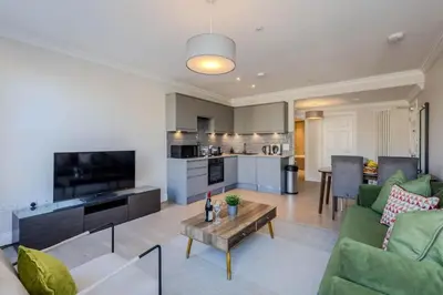 a living room with a couch and a table at Dragon Suites - Edinburgh City Centre 2 Bed Apartment in Edinburgh
