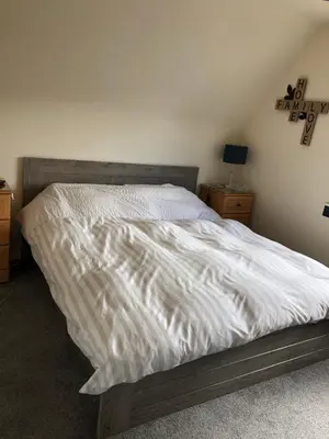 a bed with a white comforter in a bedroom at Limegrove Comfortable three bedroom house in Law