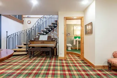 a living room with a staircase and a piano at Luxury Duplex - Sleeps 2 - Hot Tub - Parking in Glenfarg