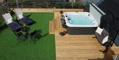 a backyard with a jacuzzi tub and two chairs at Luxury Duplex - Sleeps 2 - Hot Tub - Parking in Glenfarg