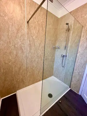a shower with a glass enclosure in a bathroom at Old Spittal Hospital Apartment - Free Parking in Stirling
