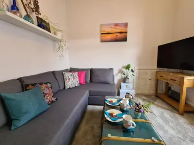 a living room with a couch and a tv at The Editor's Choice, Oban seafront apartment in Oban