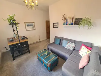 a living room with a couch and a table at The Editor's Choice, Oban seafront apartment in Oban