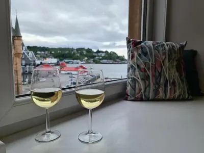 two glasses of white wine sitting on a window sill at The Editor's Choice, Oban seafront apartment in Oban