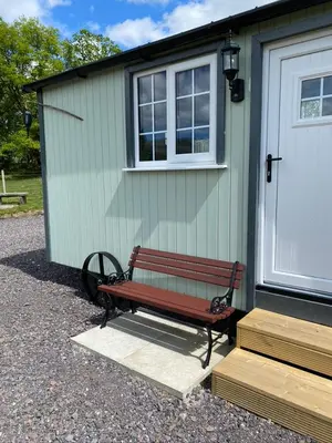 a bench sitting in front of a building at Wee Highland Hideaway Hut in Dalmally