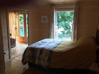 a bedroom with a bed and a large window at Off Grid 1-Bed Cabin Pets Ok 20 mins to Dunoon in Blairmore