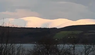a snow covered mountain with a lake in the foreground at Off Grid 1-Bed Cabin Pets Ok 20 mins to Dunoon in Blairmore