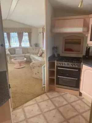a kitchen with a stove and a living room at Lyndhurst Corner 72 in Dunoon