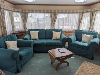 a living room with blue couches and a coffee table at 34 Glenfinart Park in Dunoon