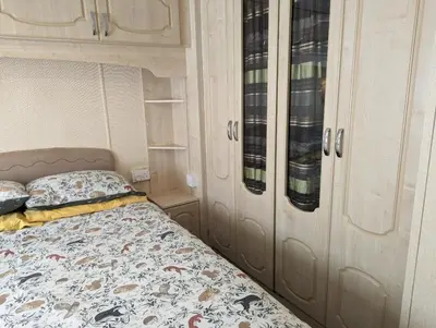 a bedroom with a bed and some cupboards at 34 Glenfinart Park in Dunoon