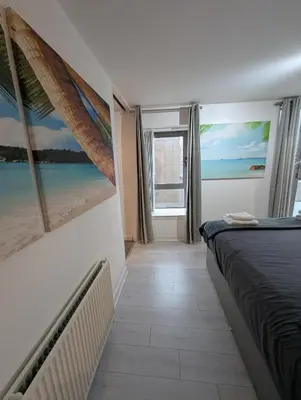 a bedroom with a bed and a view of the ocean at Glasgow City Centre Waterfront Apartment in Glasgow
