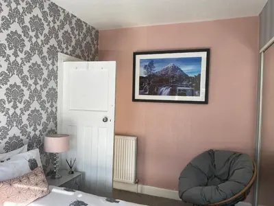 a bedroom with a bed and a picture on the wall at Nairoo in Balloch