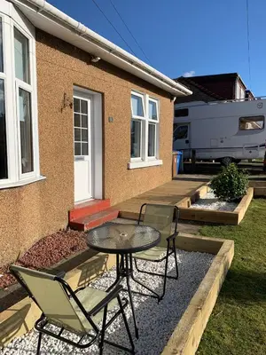 a patio with a table and chairs in front of a house at Nairoo in Balloch