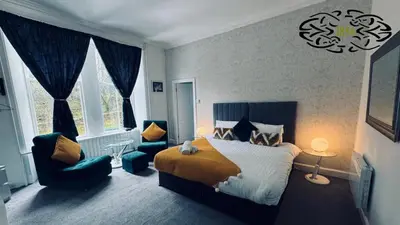 a bedroom with a bed and a couch and a chair at Royal Marine Hotel Dunoon in Kirn