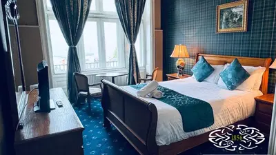a hotel room with a bed and a desk with a computer at Royal Marine Hotel Dunoon in Kirn