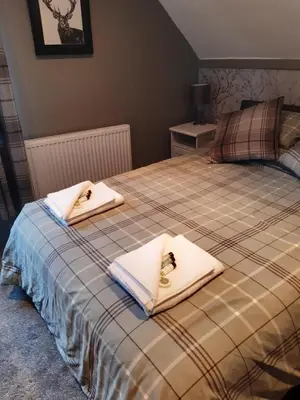 a bedroom with two beds with white towels on them at Ardgowan Cottage in Brodick