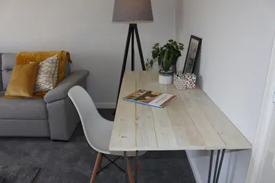 a wooden table in a living room with a couch at Riverside Apartment in Ayr