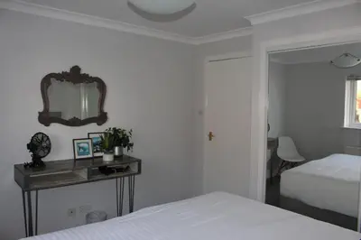 a bedroom with a bed and a mirror on the wall at Riverside Apartment in Ayr