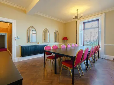 a dining room with a table and pink chairs at The Old Nunnery - Uk7122 in Skelmorlie
