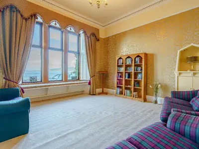 a living room with a couch and a large window at The Old Nunnery - Uk7122 in Skelmorlie