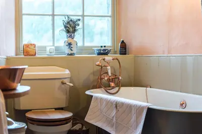 a bathroom with a tub and a toilet and a window at Queen Mary's Chamber in Peebles