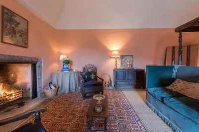 a living room with a blue couch and a fireplace at Queen Mary's Chamber in Peebles