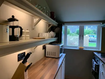 a kitchen with a counter with a microwave and a window at Barns Library in Peebles